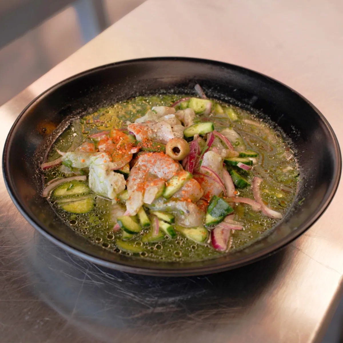 Aguachile Playa Verde con camarón crudo, pepino y cebolla morada
